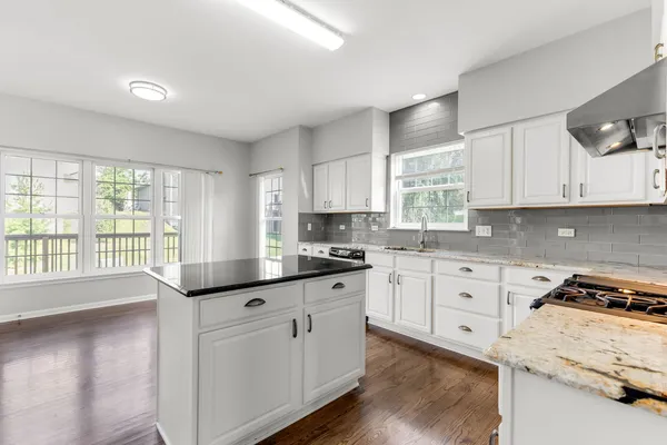 a kitchen with granite countertop white cabinets and white appliances
