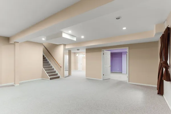 an empty room with stairs and wooden floor