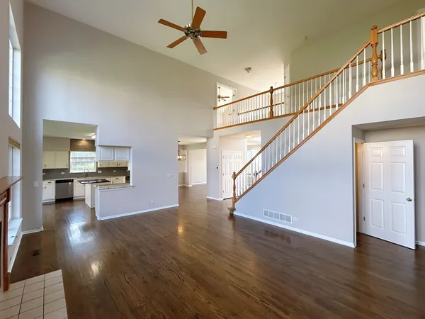 a view of a livingroom with wooden floor and stairs