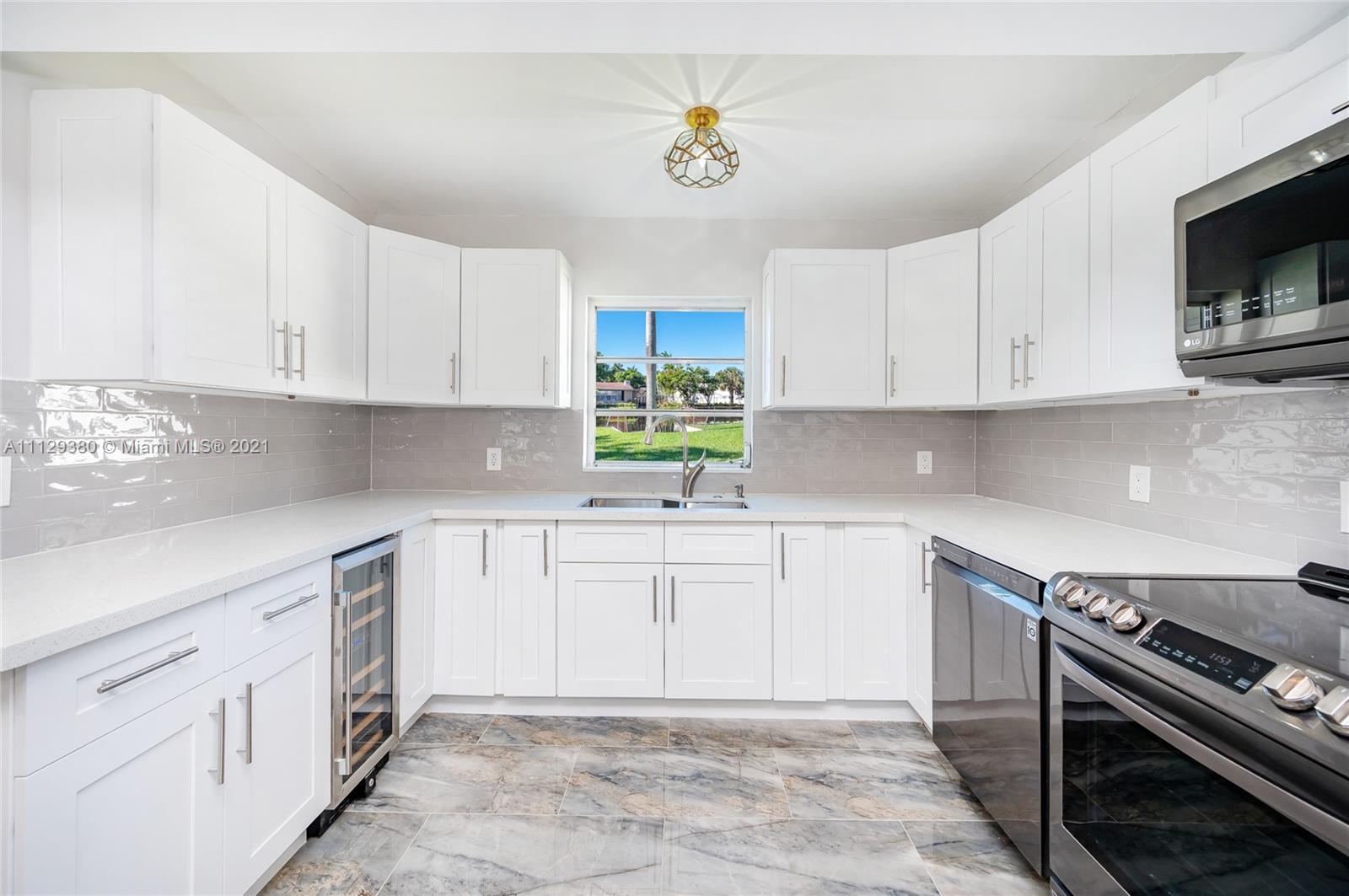 12480 Griffing Boulevard North Miami, FL 33161 - Photo 13 of 31 a kitchen with cabinets appliances and a window
