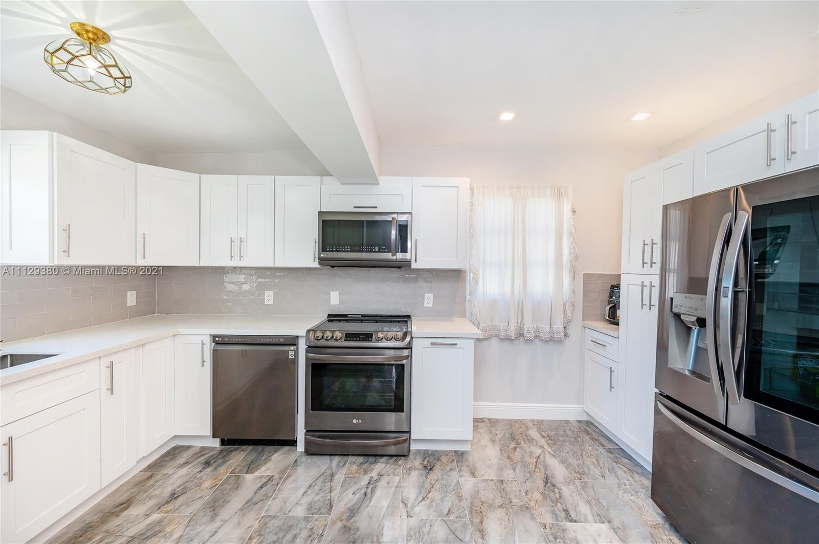 12480 Griffing Boulevard North Miami, FL 33161 - Photo 14 of 31 a kitchen with stainless steel appliances a stove a sink and a refrigerator