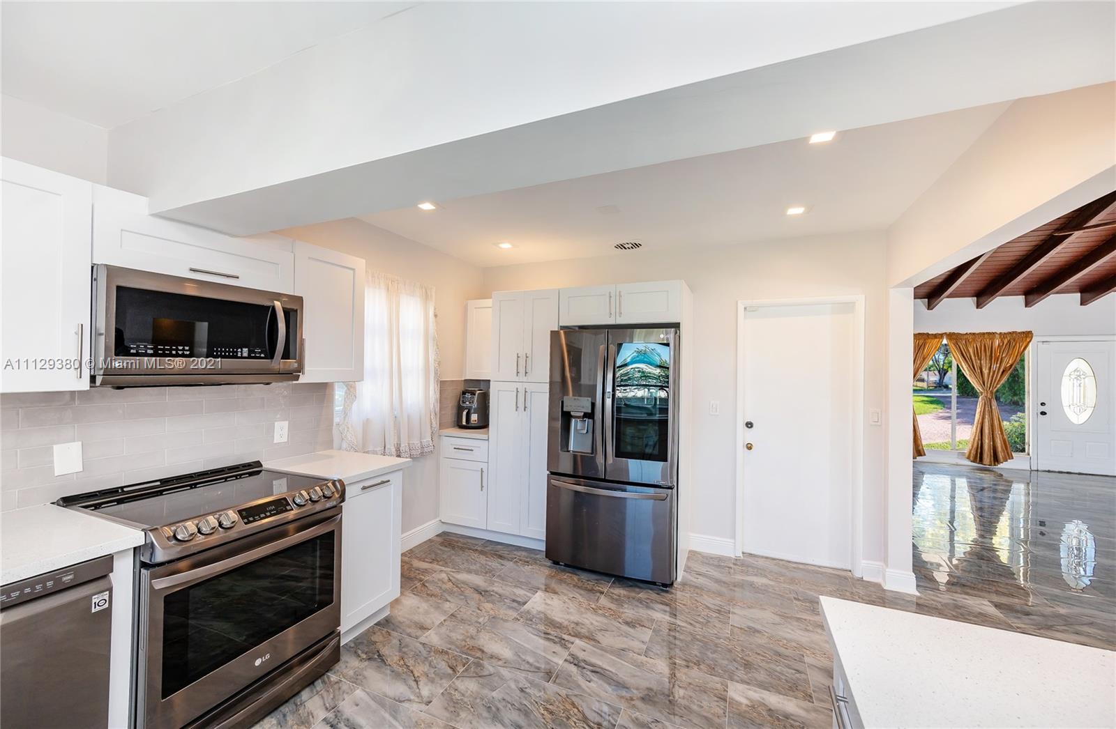 12480 Griffing Boulevard North Miami, FL 33161 - Photo 15 of 31 a kitchen with stainless steel appliances kitchen island granite countertop a stove and a refrigerator