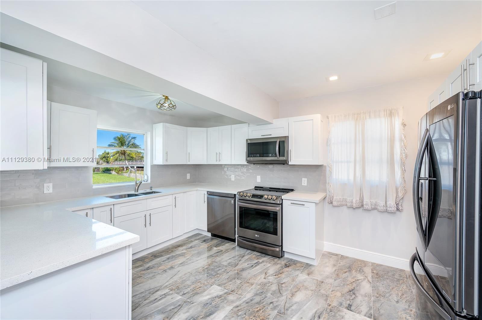 12480 Griffing Boulevard North Miami, FL 33161 - Photo 16 of 31 a kitchen with stainless steel appliances granite countertop a stove a sink and a refrigerator