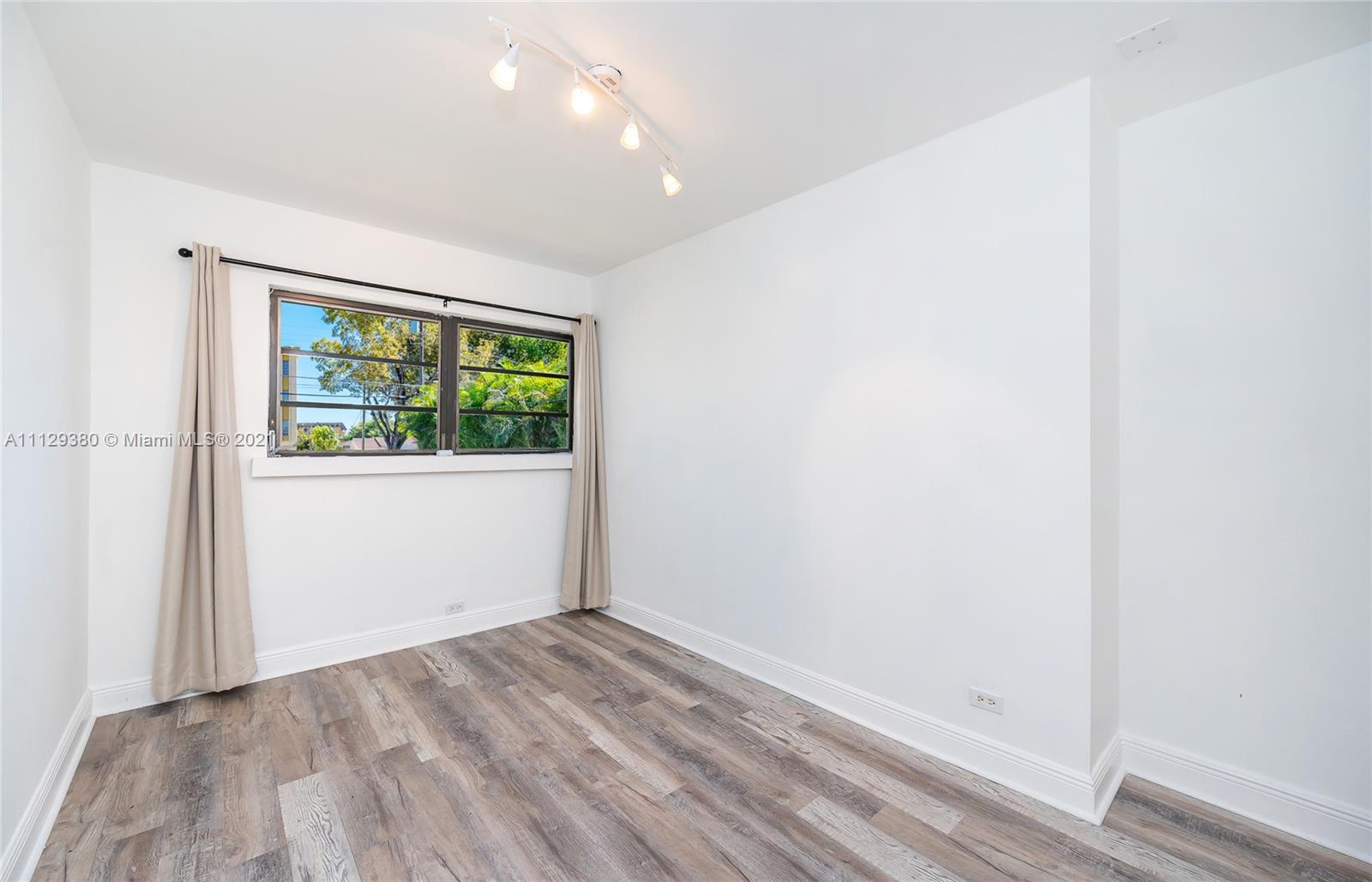 12480 Griffing Boulevard North Miami, FL 33161 - Photo 21 of 31 an empty room with wooden floor and windows