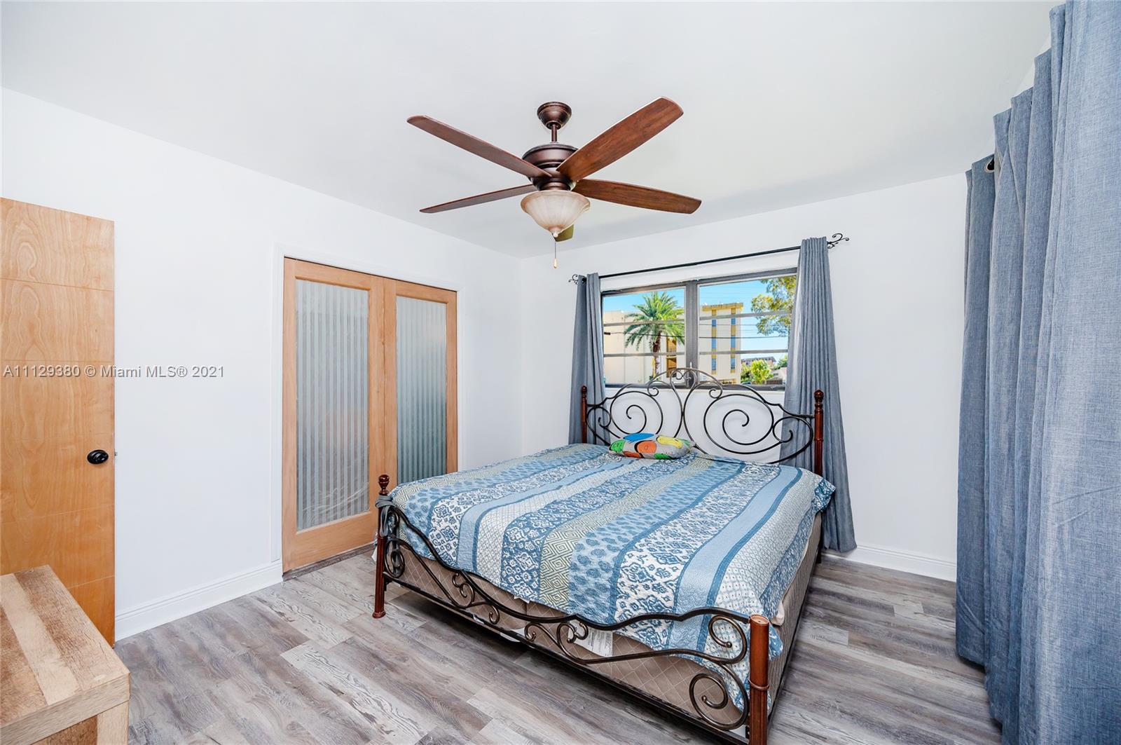 12480 Griffing Boulevard North Miami, FL 33161 - Photo 30 of 31 a bedroom with a bed and a chandelier