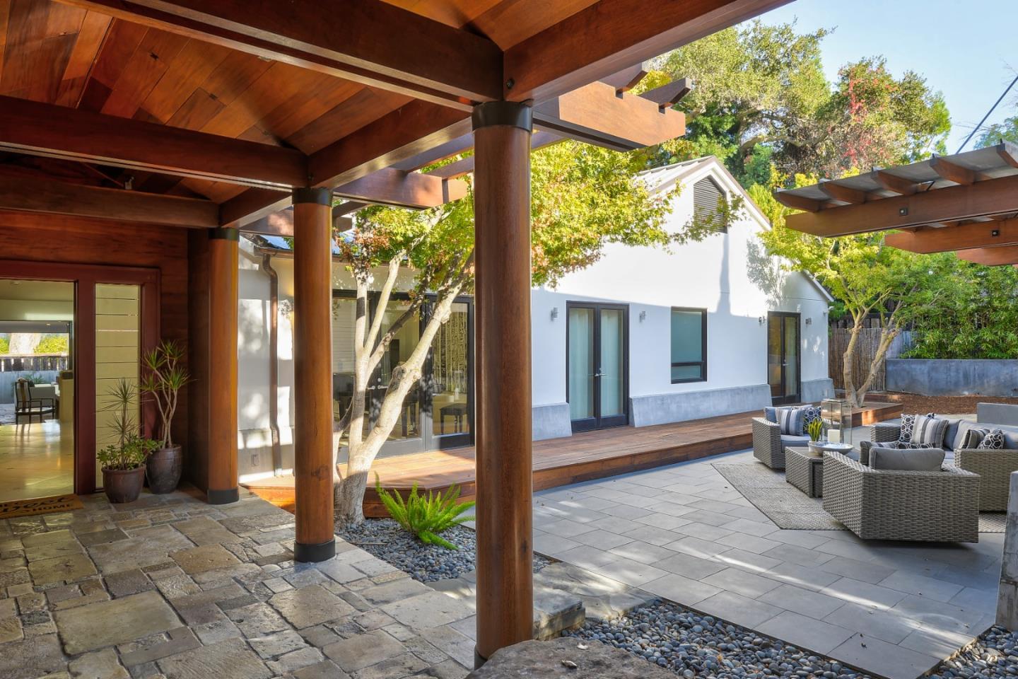 14480 Oak Place Saratoga, CA 95070 - Photo 36 of 45 a view of a patio with table and chairs potted plants and a palm tree