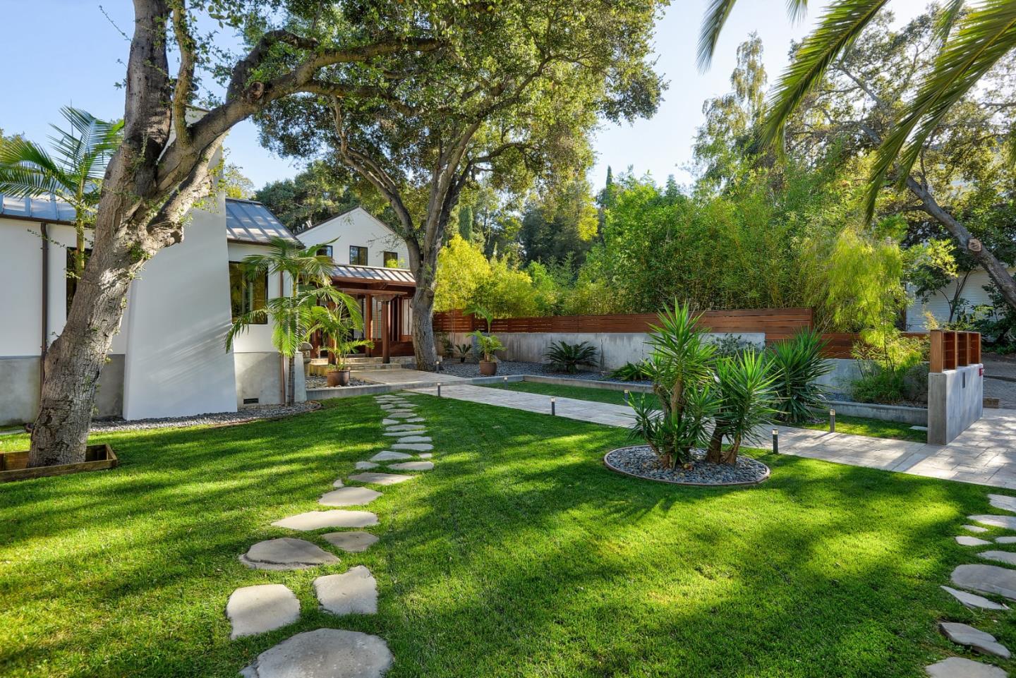 14480 Oak Place Saratoga, CA 95070 - Photo 40 of 45 a backyard of a house with table and chairs plants and large tree