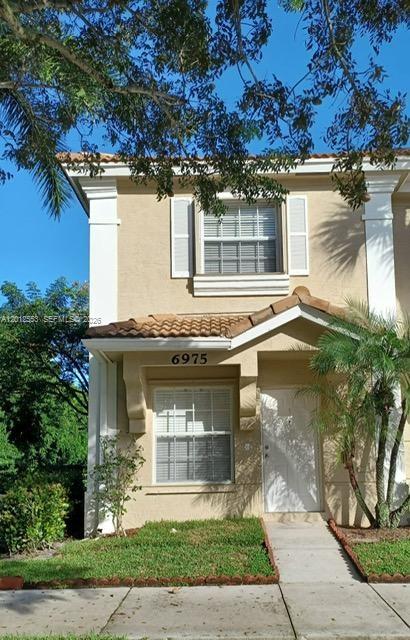 a front view of a house with a garden