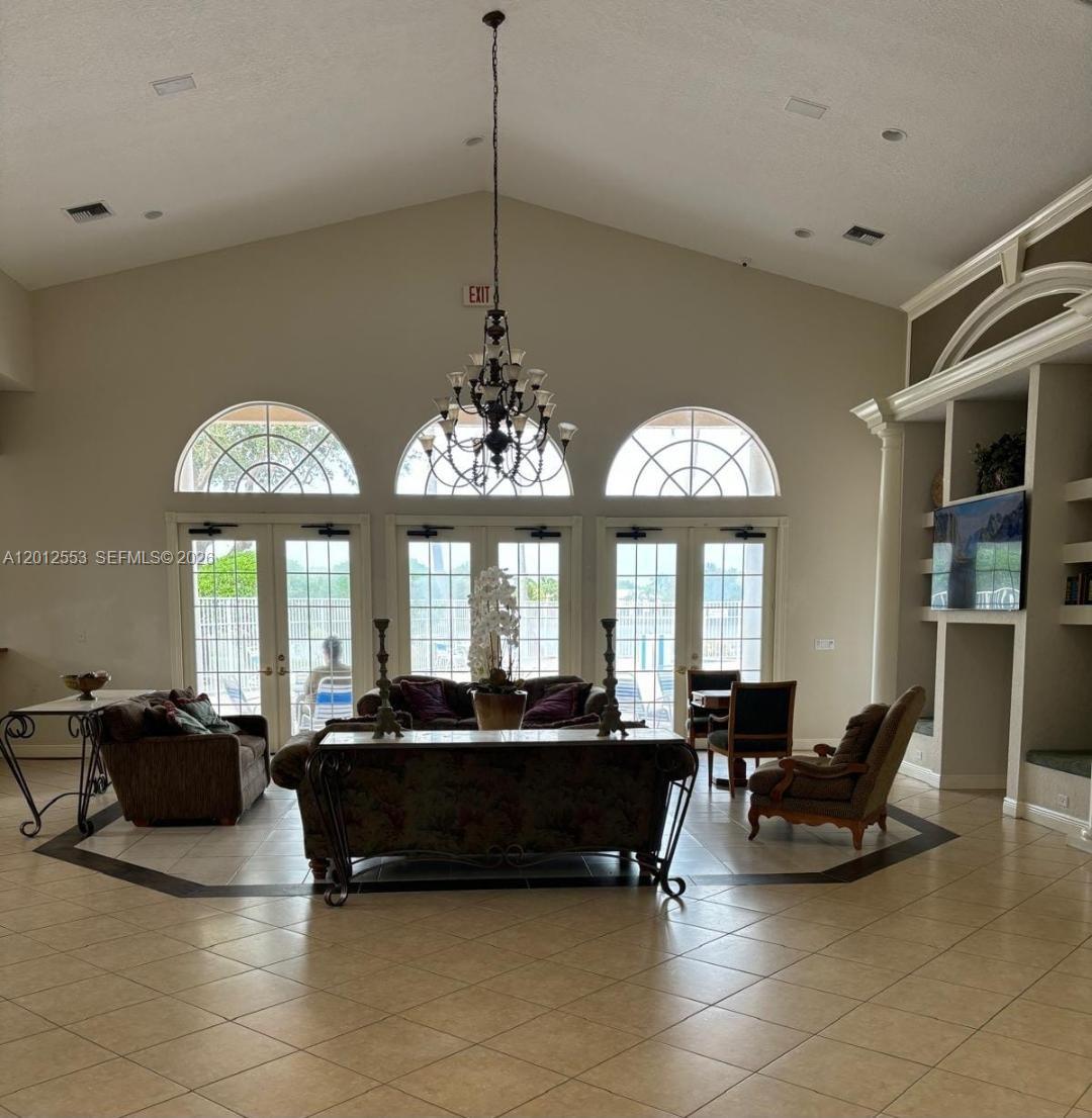 6975 Blacksmith Way Lake Worth, FL 33467 - Photo 17 of 21 a living room with furniture a chandelier and a large window