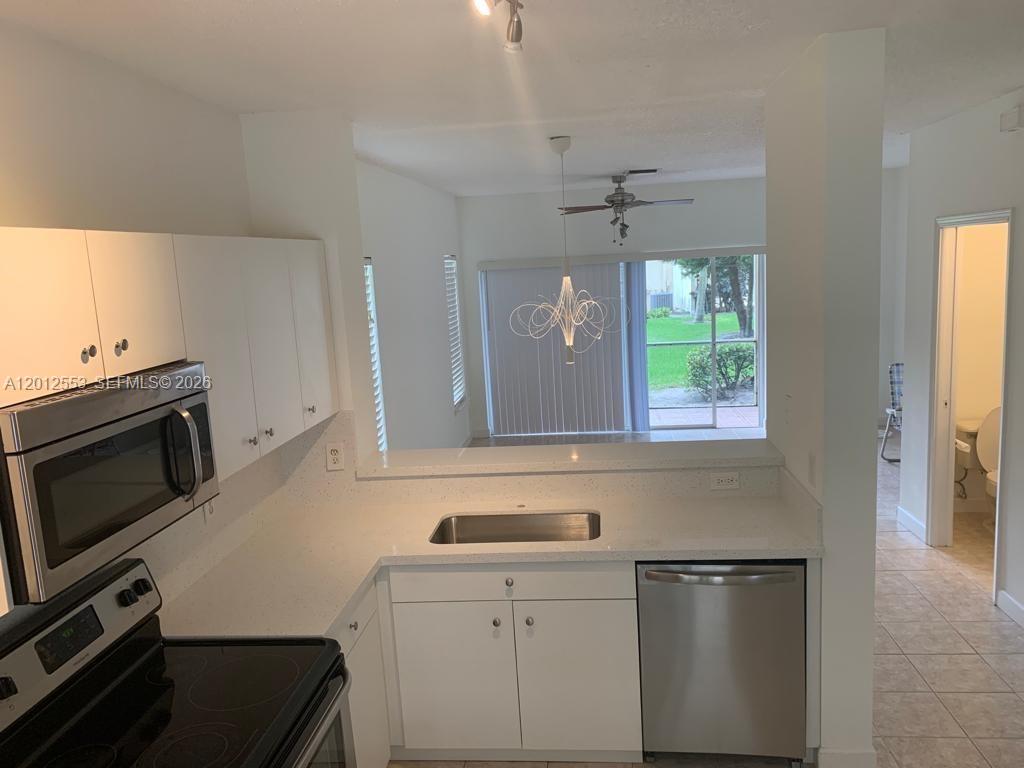6975 Blacksmith Way Lake Worth, FL 33467 - Photo 3 of 21 a kitchen with a sink stove and microwave