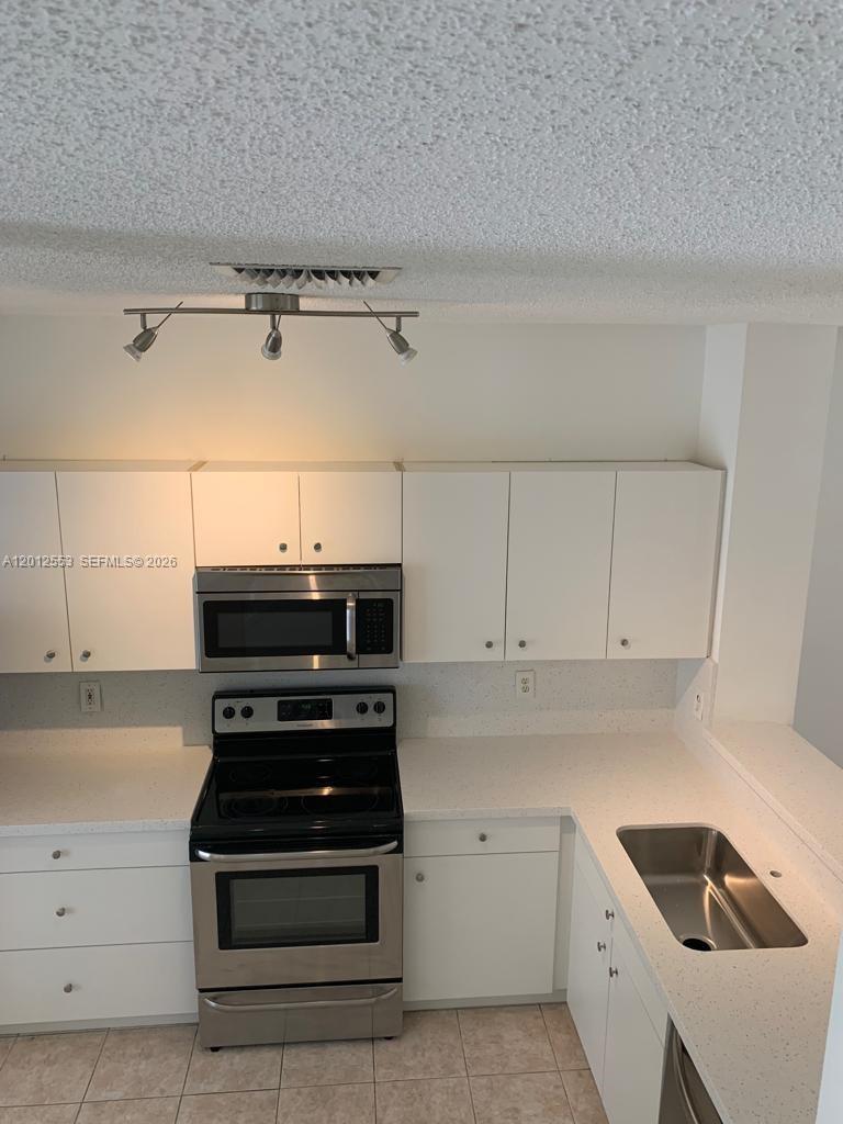 6975 Blacksmith Way Lake Worth, FL 33467 - Photo 4 of 21 a kitchen with granite countertop a stove and a sink