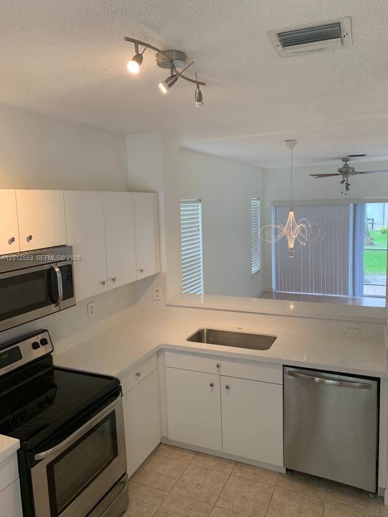 6975 Blacksmith Way Lake Worth, FL 33467 - Photo 6 of 21 a kitchen with a sink and white cabinets