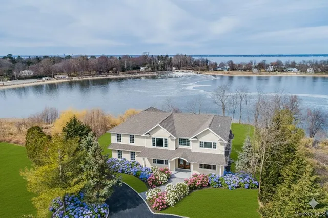 an aerial view of a house with a garden and a lake view
