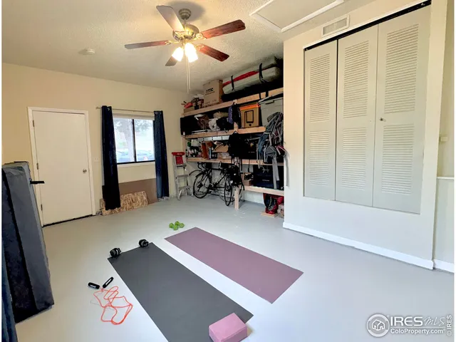 a living room with furniture a bookshelf and a window