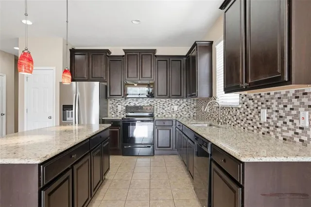 a kitchen with granite countertop a refrigerator and a sink