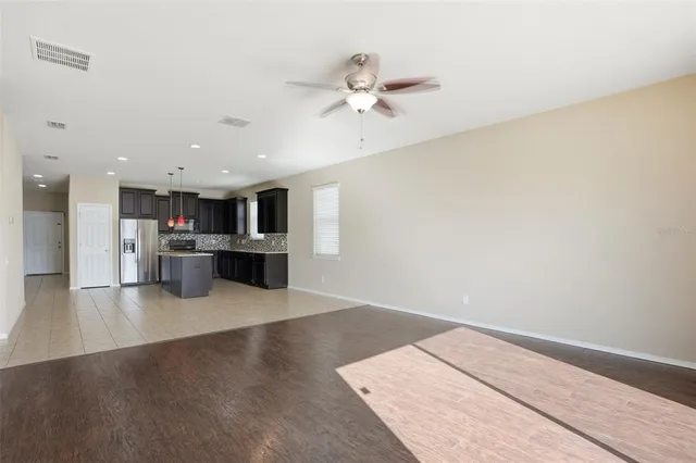 a view of kitchen with kitchen island microwave and wooden floor
