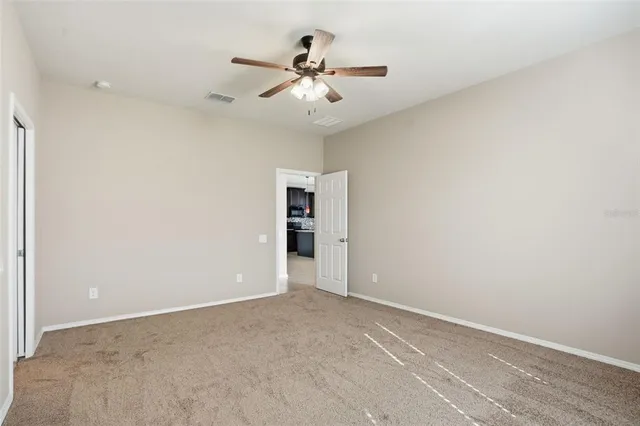 an empty room with closet and fan