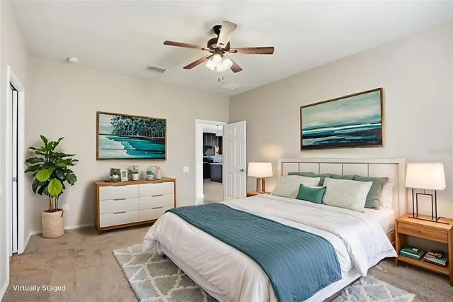 a bedroom with a bed potted plant and a flat screen tv