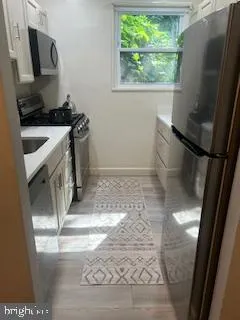 a bathroom with a sink a toilet a window and vanity