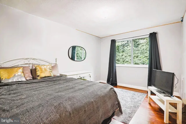 a bedroom with a bed and a tv on the dresser