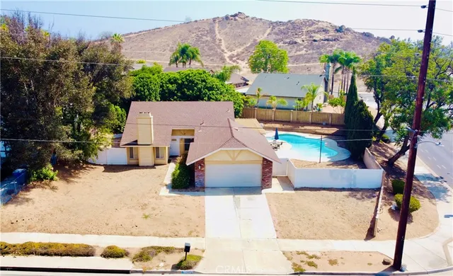 an aerial view of a house with a yard and a large tree