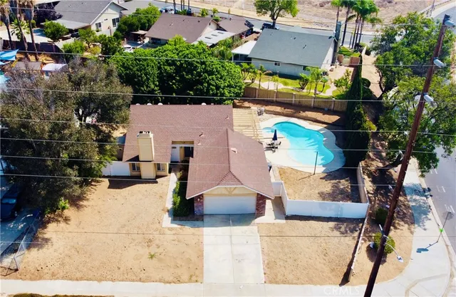 a view of house with backyard and trees in the background