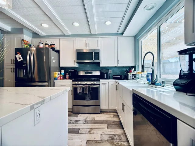 a kitchen with stainless steel appliances granite countertop a sink and a stove