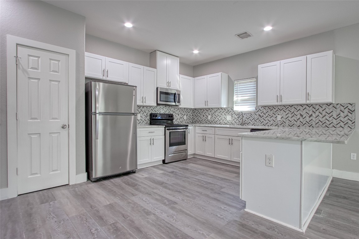 9306 Bean Street, Unit B Houston, TX 77028 - Photo 12 of 15 a kitchen with a refrigerator a sink and cabinets