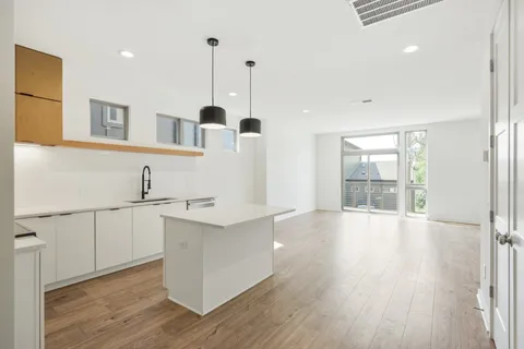a view of a kitchen with a sink and dishwasher wooden cabinets with wooden floor