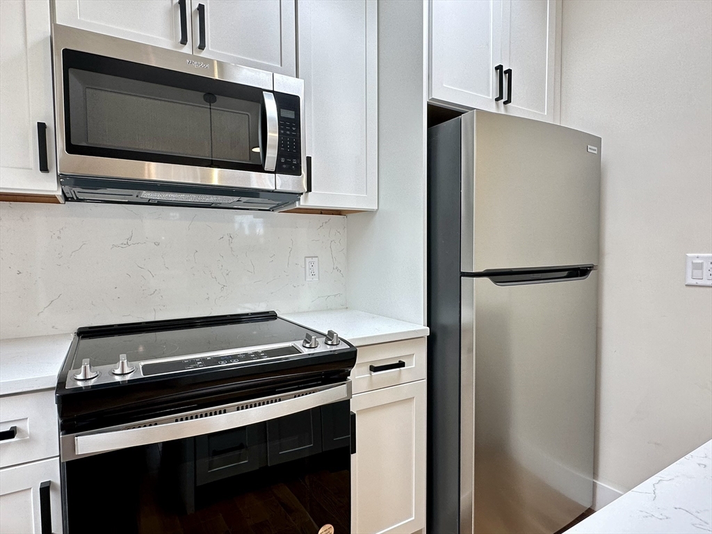 64 North Margin Street, Unit 4R Boston, MA 02113 - Photo 6 of 18 a kitchen with stainless steel appliances and cabinets