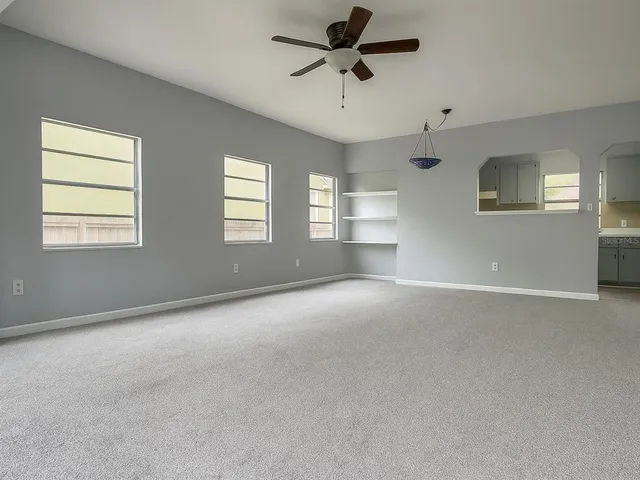 a view of a livingroom with a ceiling fan and window