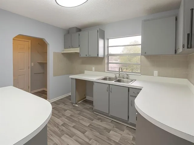 a kitchen with a sink cabinets and window