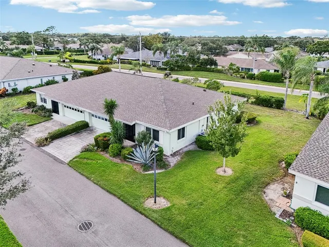 an aerial view of a house with a garden and lake view