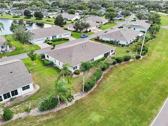 an aerial view of residential houses with outdoor space and parking