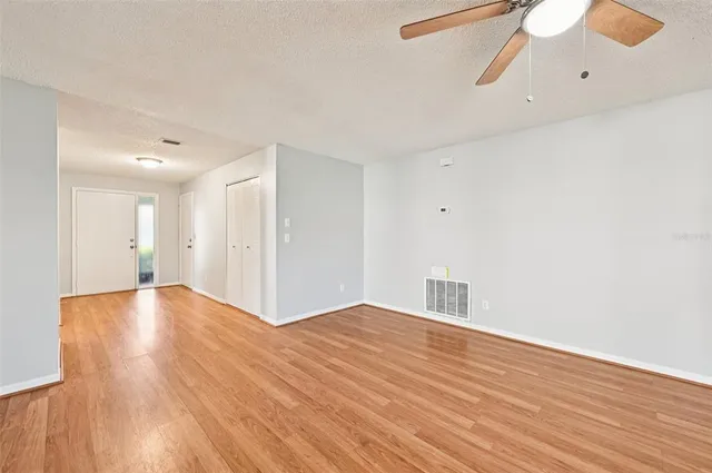 a view of an empty room with wooden floor