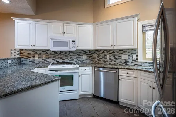a kitchen with stainless steel appliances granite countertop a sink stove and cabinets