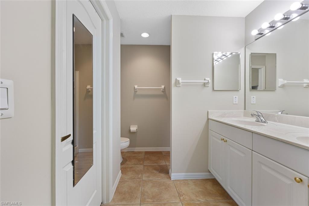 348 Dover Place, Unit C103 Naples, FL 34104 - Photo 11 of 27 a bathroom with a double vanity sink and mirror