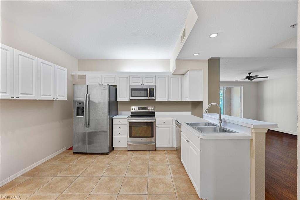 348 Dover Place, Unit C103 Naples, FL 34104 - Photo 14 of 27 a large kitchen with stainless steel appliances granite countertop a stove a sink and a refrigerator