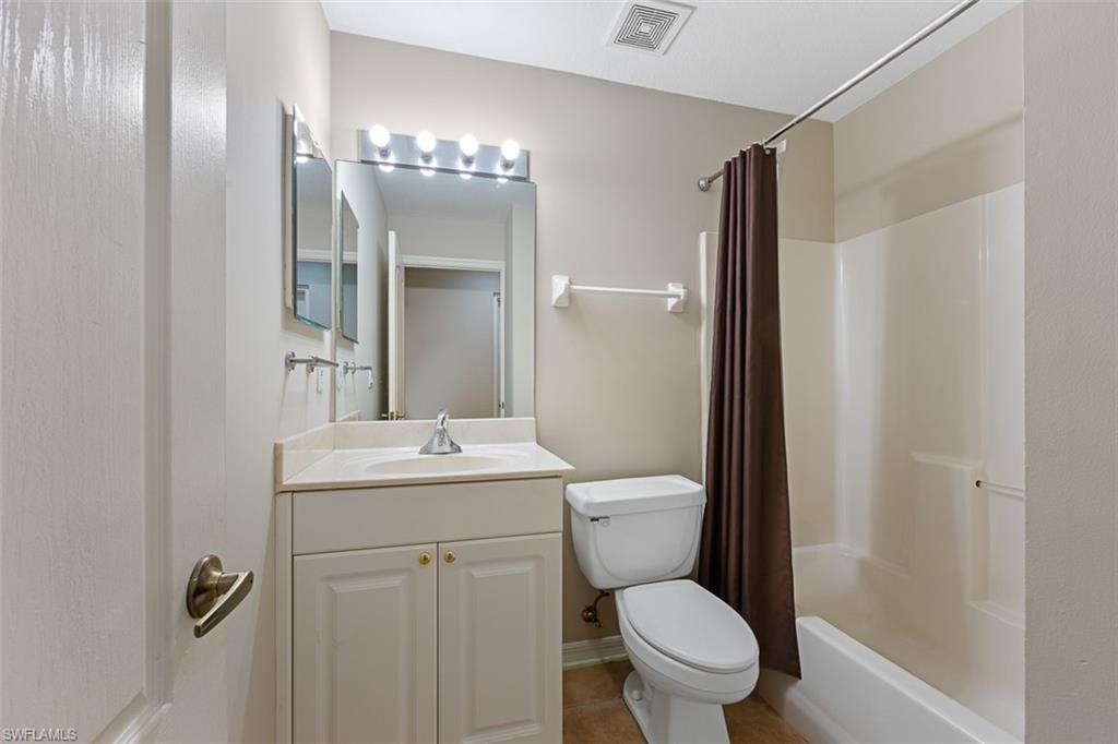 348 Dover Place, Unit C103 Naples, FL 34104 - Photo 16 of 27 a bathroom with a toilet a sink and mirror