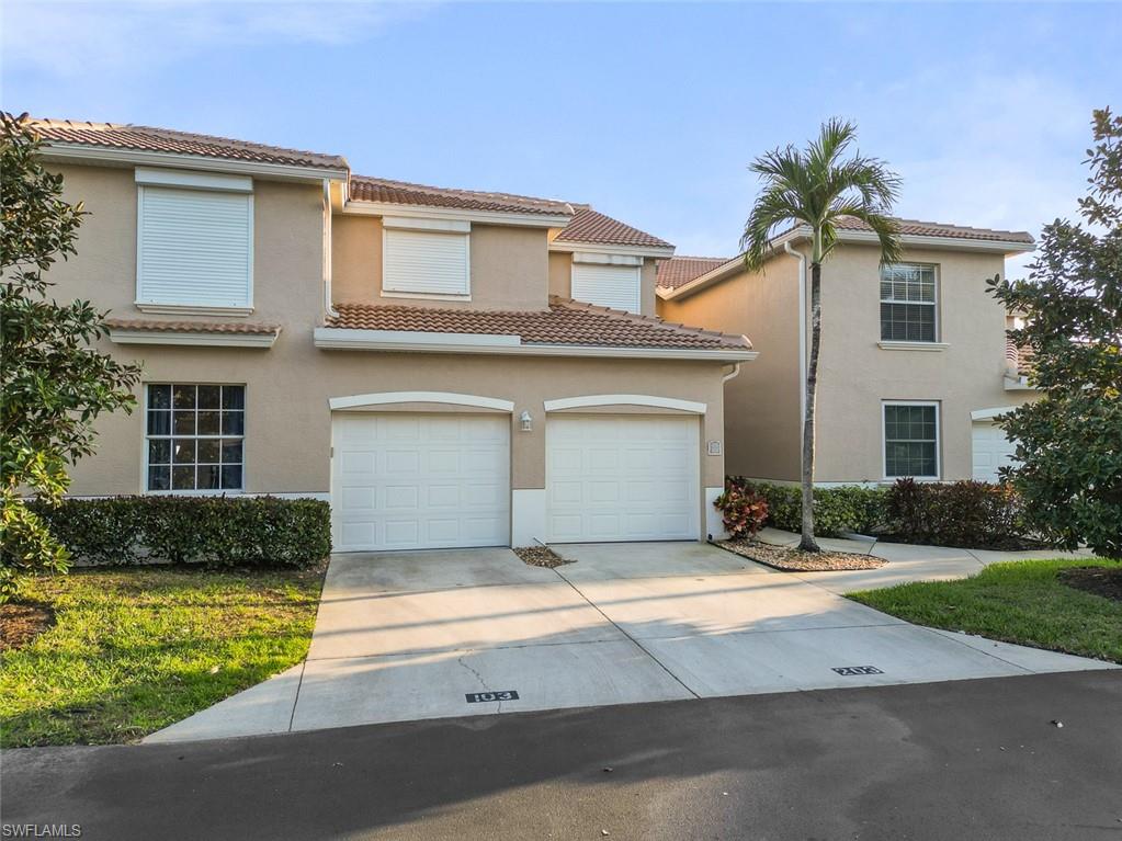 348 Dover Place, Unit C103 Naples, FL 34104 - Photo 17 of 27 a front view of a house with a yard and garage