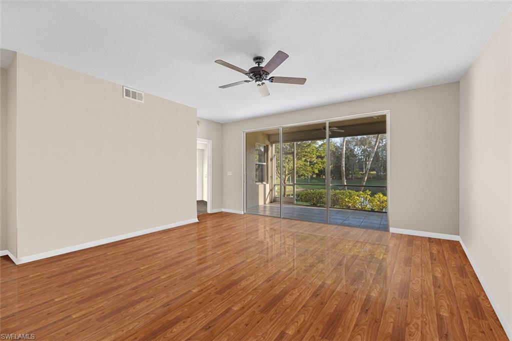 348 Dover Place, Unit C103 Naples, FL 34104 - Photo 2 of 27 a view of an empty room with a window and wooden floor