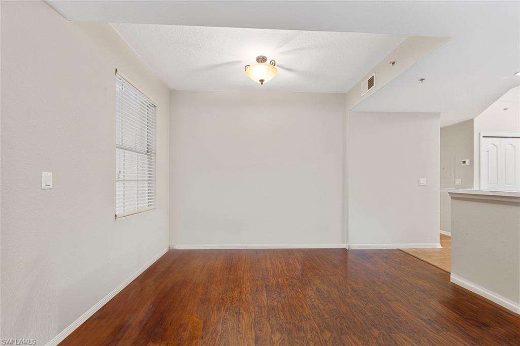 348 Dover Place, Unit C103 Naples, FL 34104 - Photo 7 of 27 an empty room with wooden floor and windows