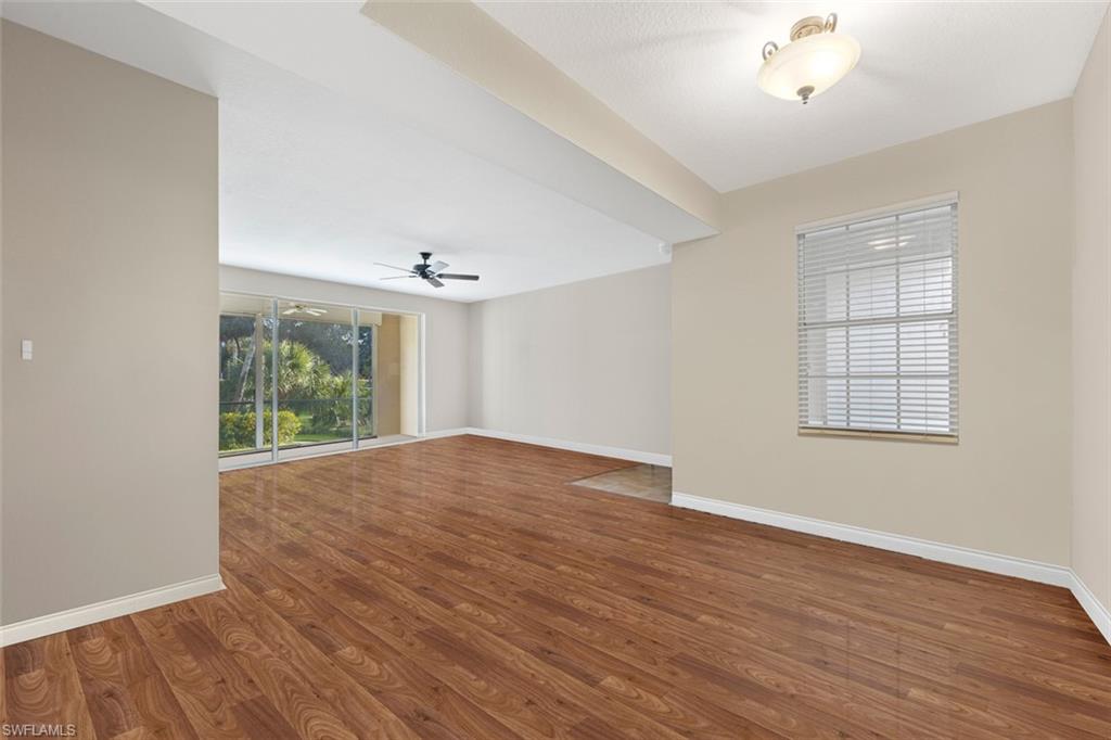 348 Dover Place, Unit C103 Naples, FL 34104 - Photo 8 of 27 wooden floor in an empty room with a window