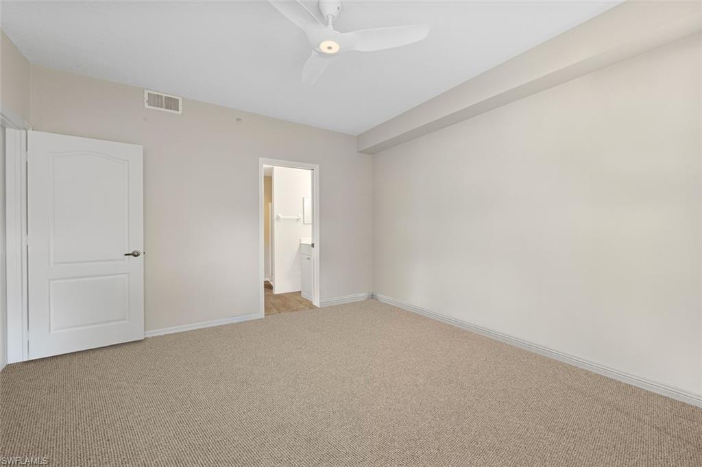 348 Dover Place, Unit C103 Naples, FL 34104 - Photo 10 of 27 a view of an empty room and chandelier fan