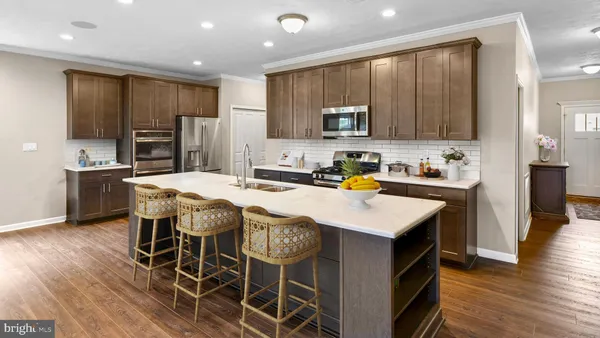 a kitchen with stainless steel appliances granite countertop a table chairs sink refrigerator and microwave
