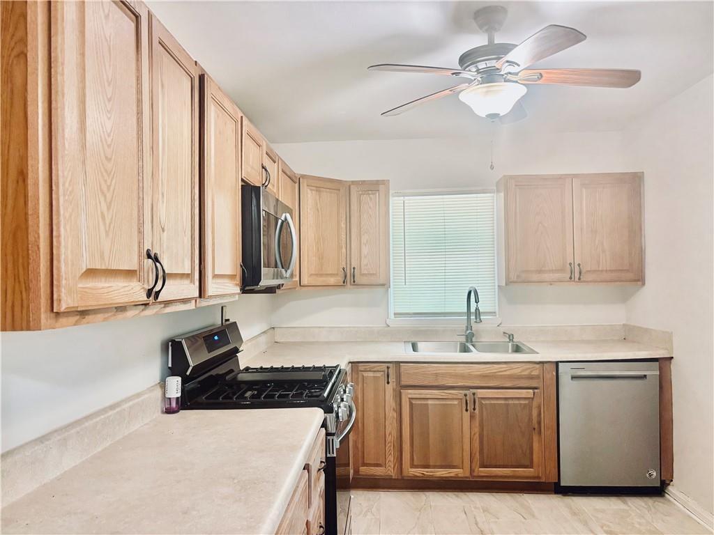 269 Florida Avenue Southwest Atlanta, GA 30310 - Photo 7 of 11 a kitchen with a sink dishwasher a stove a dining table and chairs with wooden floor