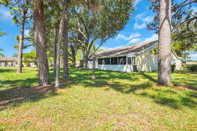 a view of a house with backyard and a tree