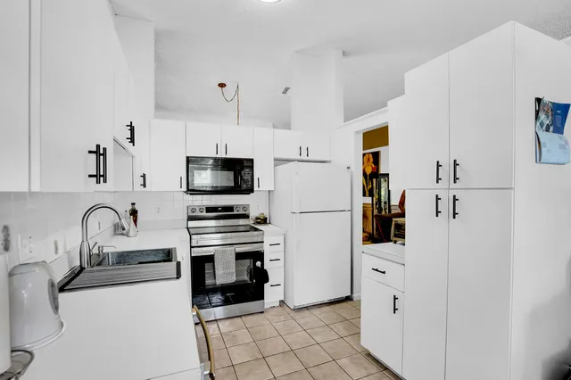 a kitchen with granite countertop a sink stove and refrigerator