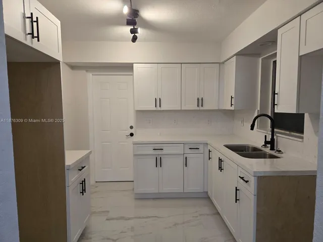 a kitchen with cabinets appliances and a sink