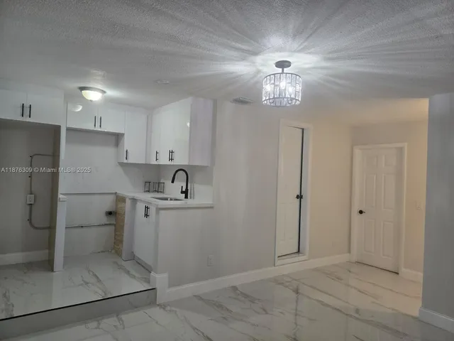 a view of cabinets and chandelier fan